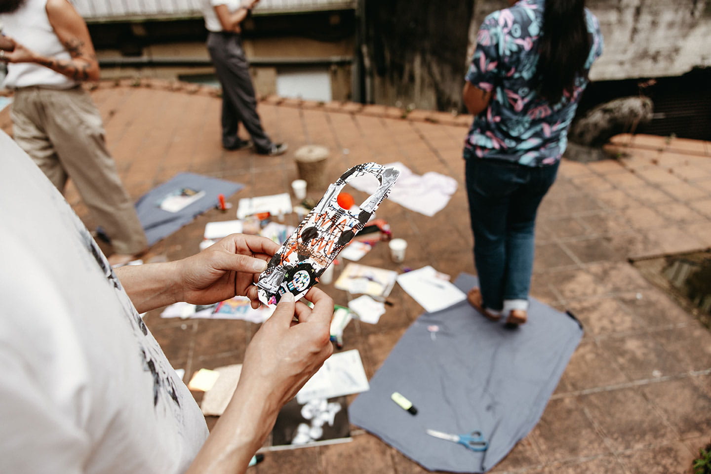Grupo de personas trabajando con materiales artisticos en el suelo durante un taller